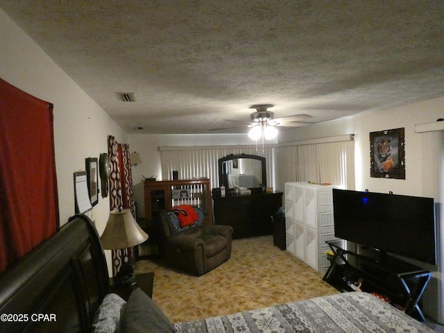 bedroom featuring ceiling fan, a textured ceiling, and carpet flooring