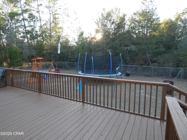 wooden terrace featuring a playground and a trampoline