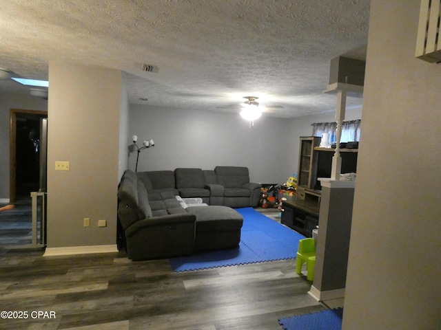 living room featuring dark hardwood / wood-style flooring and a textured ceiling