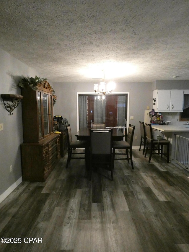 dining area featuring dark hardwood / wood-style floors, a notable chandelier, and a textured ceiling