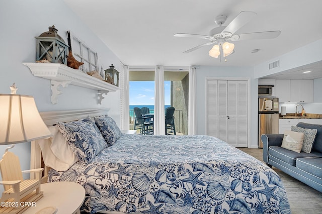 bedroom with stainless steel refrigerator, sink, access to outside, ceiling fan, and a closet