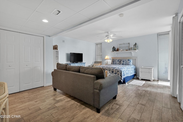 bedroom featuring a drop ceiling, ceiling fan, and a closet