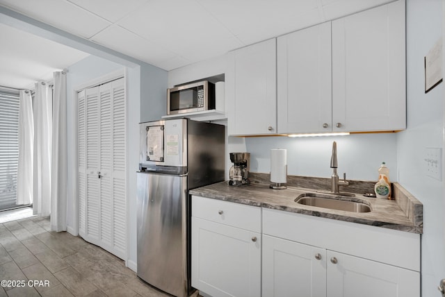 kitchen with white cabinetry, sink, and stainless steel appliances