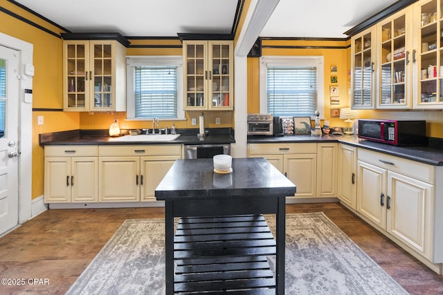 kitchen with ornamental molding, a healthy amount of sunlight, dishwasher, and sink