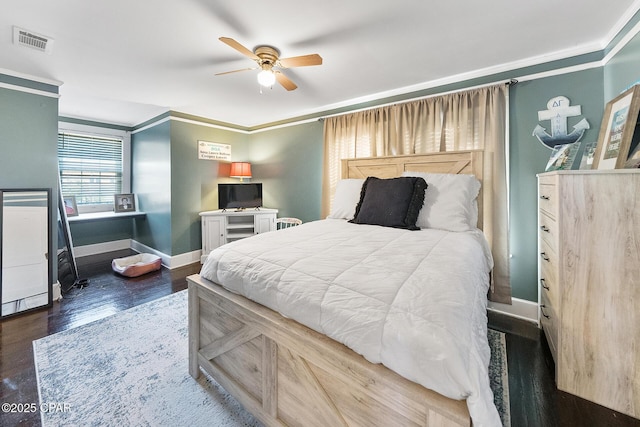 bedroom with ornamental molding, ceiling fan, and dark hardwood / wood-style flooring