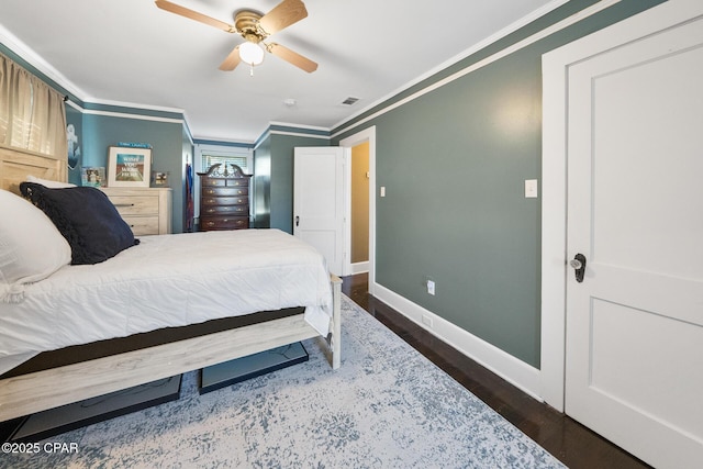 bedroom with dark hardwood / wood-style flooring, crown molding, and ceiling fan