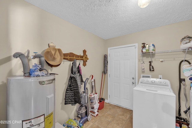 clothes washing area featuring water heater, washer / dryer, light tile patterned floors, and a textured ceiling