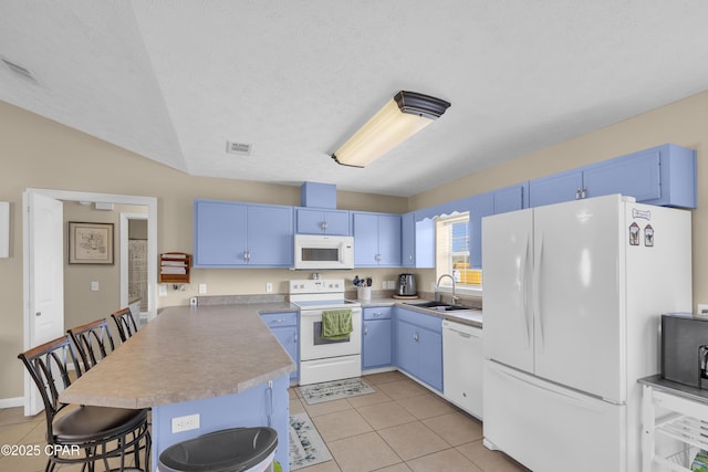 kitchen with white appliances, blue cabinets, a breakfast bar, and sink