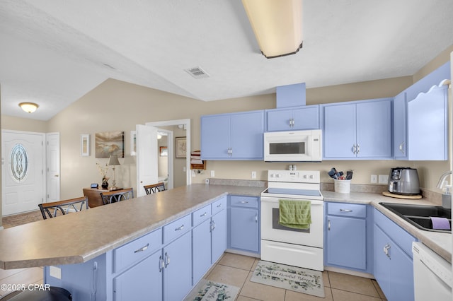 kitchen with white appliances, a kitchen breakfast bar, kitchen peninsula, and sink