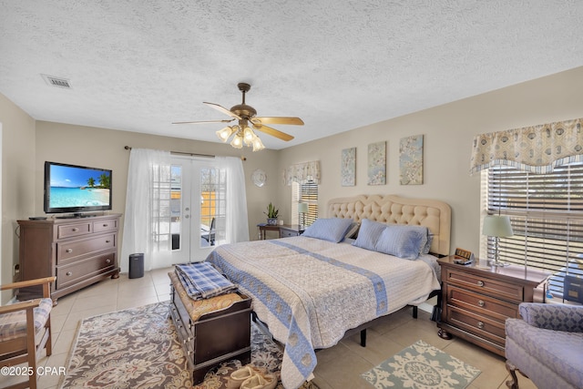 tiled bedroom with a textured ceiling, access to outside, french doors, and ceiling fan