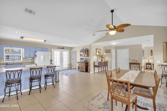 dining area featuring light tile patterned flooring, vaulted ceiling, sink, ceiling fan, and french doors