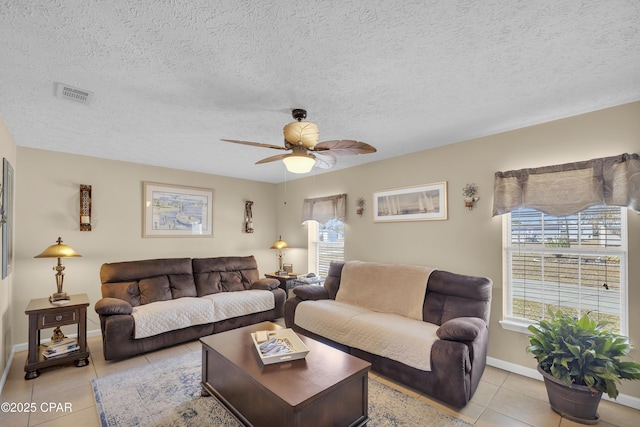 living room featuring light tile patterned floors, a textured ceiling, and ceiling fan