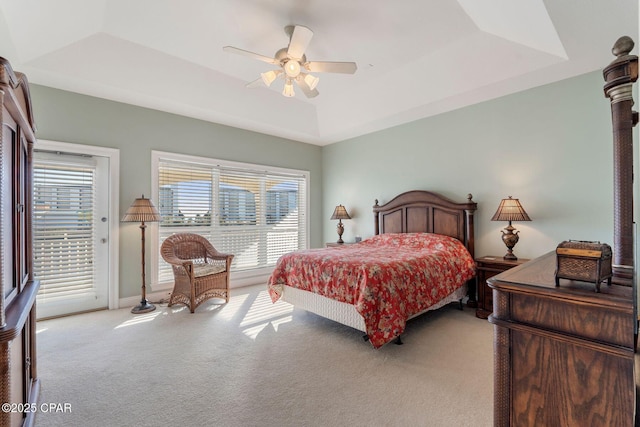 bedroom featuring light carpet, access to outside, a raised ceiling, and ceiling fan