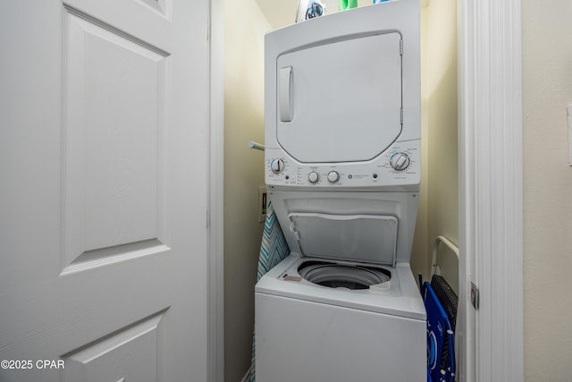 laundry area featuring stacked washer / drying machine