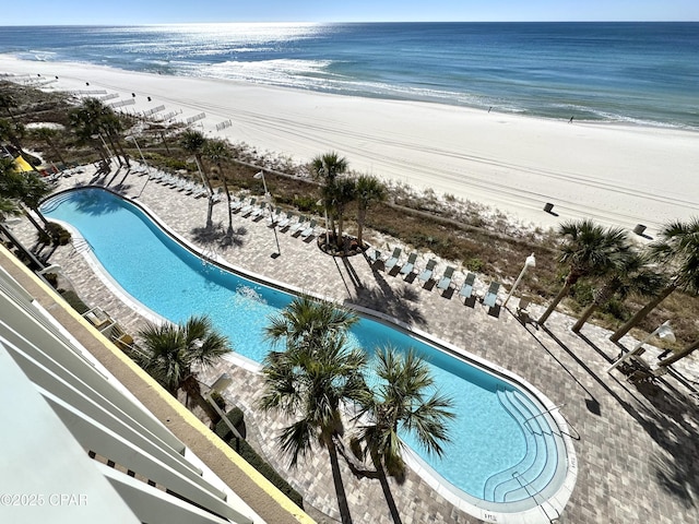 view of pool featuring a view of the beach and a water view