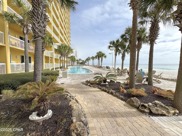 view of swimming pool featuring a patio and a water view