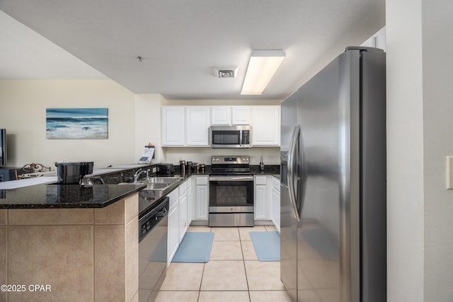 kitchen featuring sink, white cabinetry, light tile patterned floors, kitchen peninsula, and stainless steel appliances