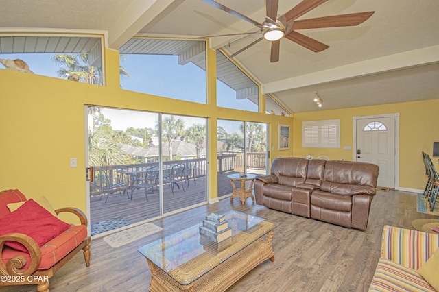 living room with wood-type flooring, vaulted ceiling with beams, and ceiling fan