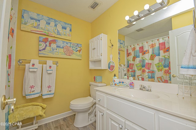 bathroom featuring wood-type flooring, vanity, toilet, a textured ceiling, and a shower with curtain