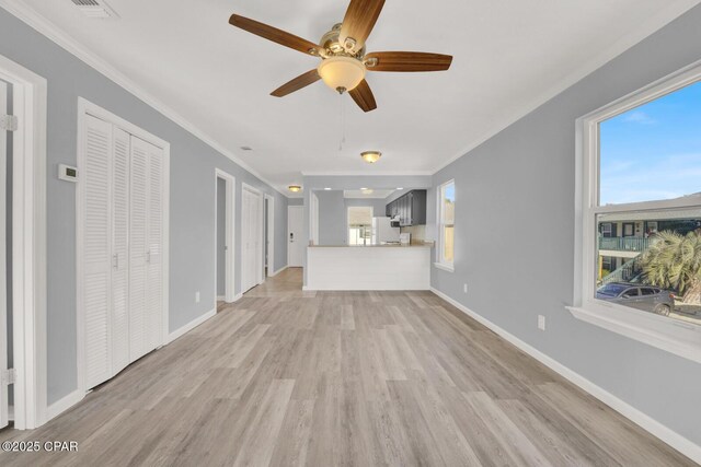 kitchen with ornamental molding, white fridge, a wealth of natural light, and kitchen peninsula