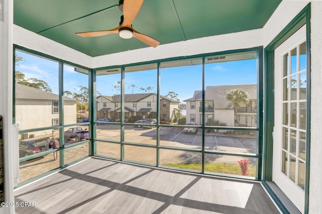 unfurnished sunroom featuring ceiling fan