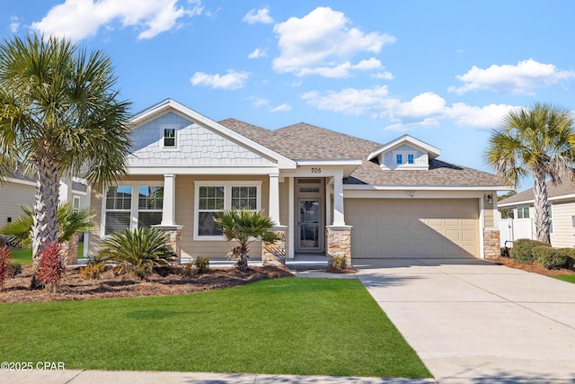 view of front of home with an attached garage, driveway, stone siding, roof with shingles, and a front lawn