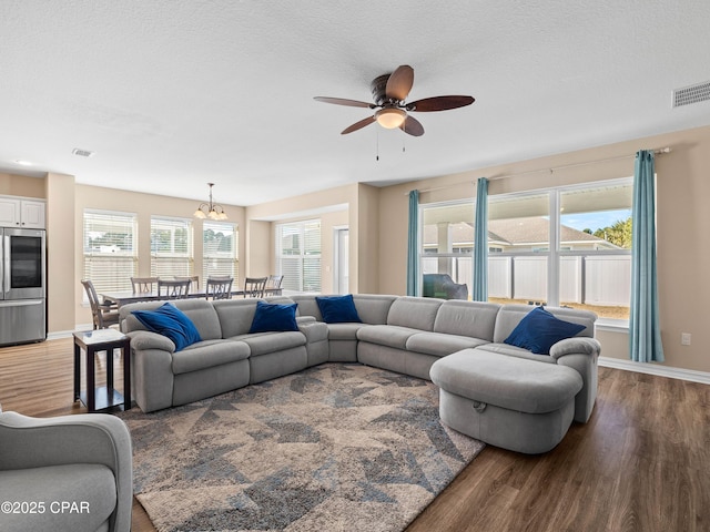 living room featuring visible vents, baseboards, and wood finished floors