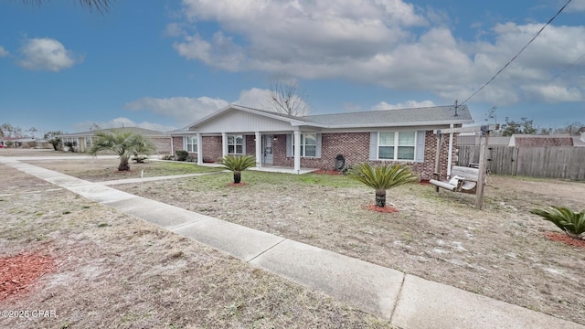 ranch-style house featuring brick siding and fence