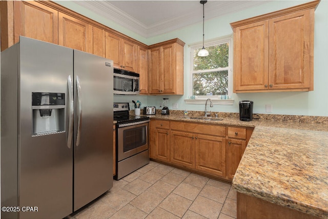 kitchen featuring brown cabinetry, stainless steel appliances, crown molding, and a sink