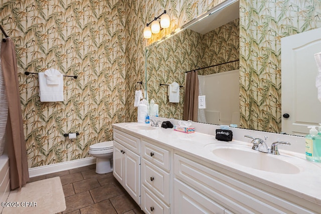 bathroom with wallpapered walls, toilet, baseboards, and a sink