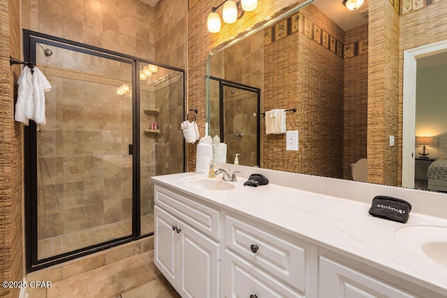 bathroom with double vanity, a shower stall, tile patterned floors, and a sink