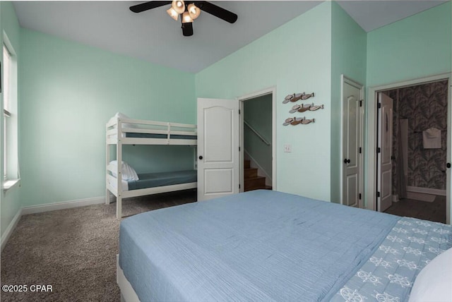 carpeted bedroom featuring lofted ceiling, baseboards, and ceiling fan