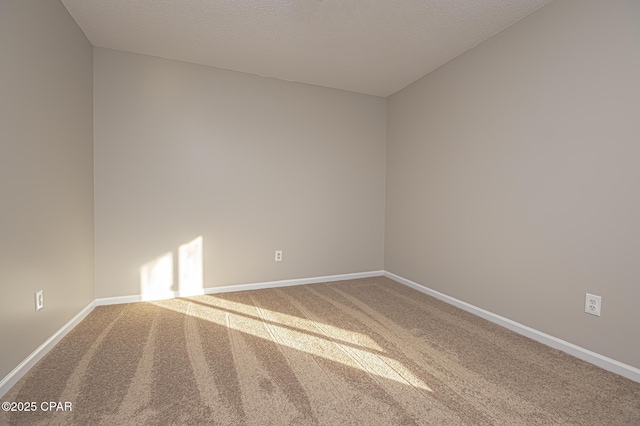 carpeted empty room featuring a textured ceiling