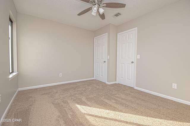 unfurnished bedroom featuring ceiling fan, a textured ceiling, and carpet flooring