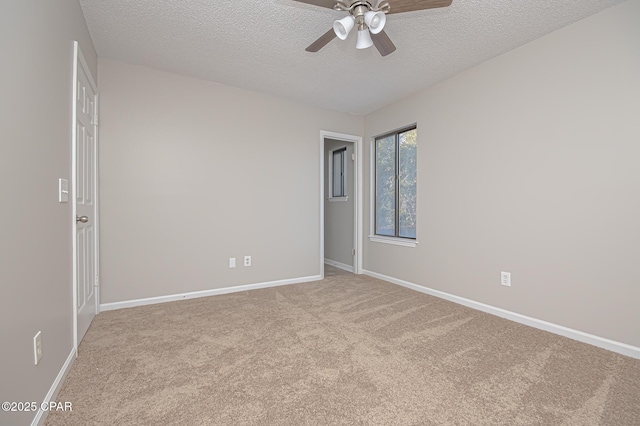 carpeted spare room featuring ceiling fan and a textured ceiling