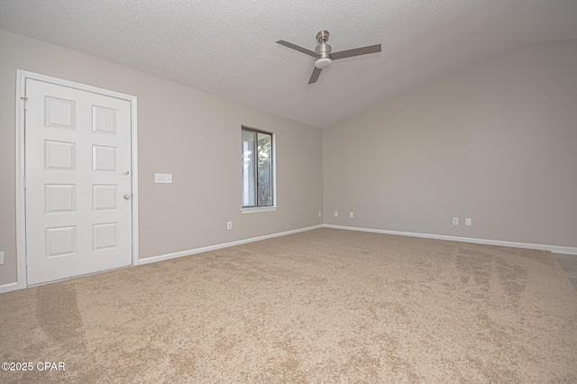 carpeted empty room with ceiling fan, lofted ceiling, and a textured ceiling