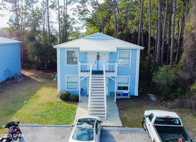 view of front of home featuring a front lawn and central air condition unit