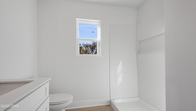 bathroom featuring vanity, hardwood / wood-style floors, toilet, and walk in shower