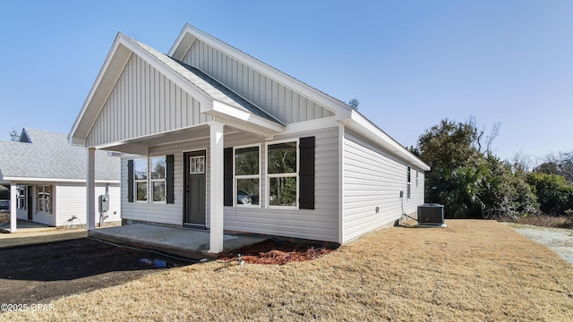 view of front of property featuring central AC unit, a patio area, and a front lawn