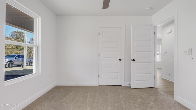 unfurnished bedroom with light colored carpet, ceiling fan, and a closet