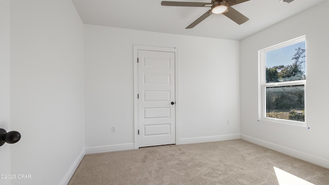 empty room with light colored carpet and ceiling fan