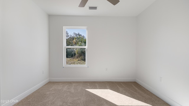 carpeted spare room featuring ceiling fan