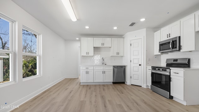 kitchen with white cabinetry, sink, decorative backsplash, and appliances with stainless steel finishes