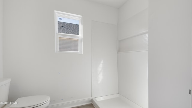 bathroom featuring a shower and toilet