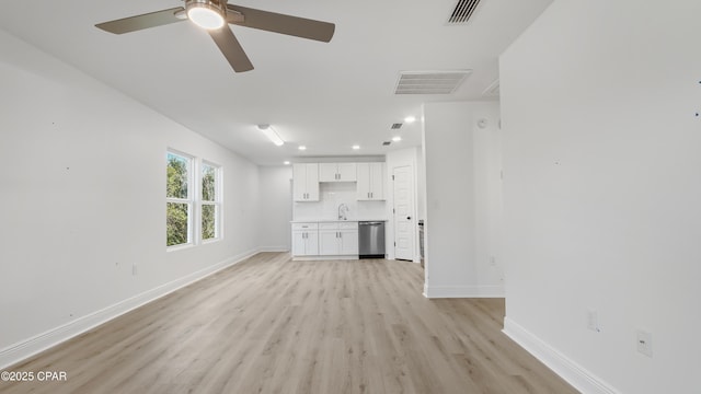 unfurnished living room with sink, ceiling fan, and light hardwood / wood-style flooring