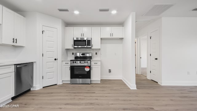 kitchen featuring white cabinetry, stainless steel appliances, and light wood-type flooring