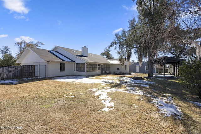 rear view of house with a gazebo, a sunroom, and a lawn