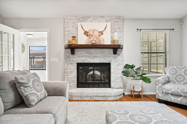 living room featuring a brick fireplace and hardwood / wood-style flooring