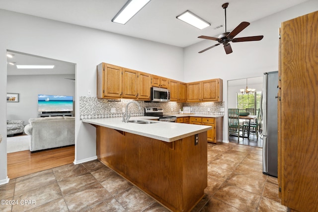 kitchen with sink, a breakfast bar, appliances with stainless steel finishes, tasteful backsplash, and kitchen peninsula