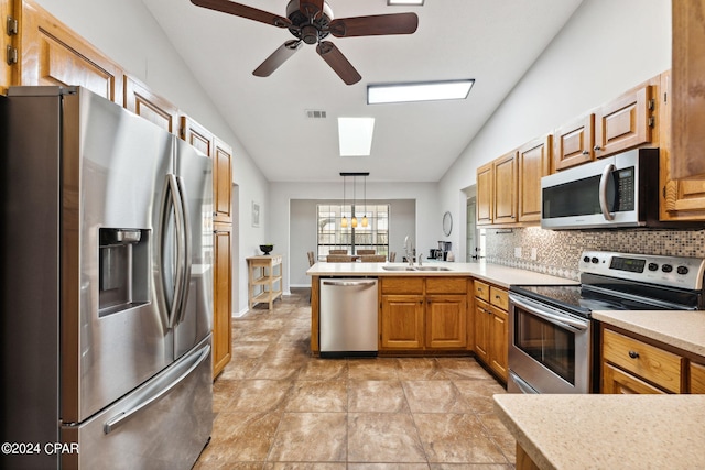 kitchen with sink, tasteful backsplash, decorative light fixtures, appliances with stainless steel finishes, and kitchen peninsula